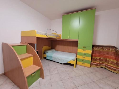 een slaapkamer met een bed en een stapelbed met groene kasten bij Sorso, 18km di spiagge low-cost in Sorso