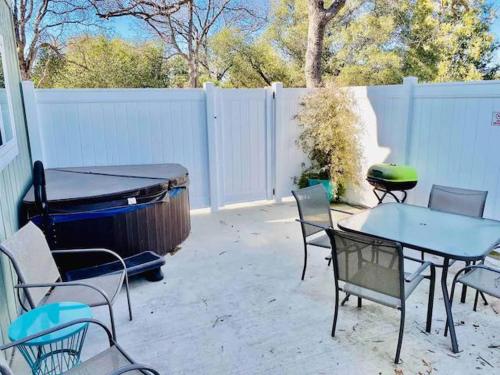 a patio with a table and chairs and a grill at Raccoon Hideout Hot Tub BBQ Arcade Darts in Oakhurst