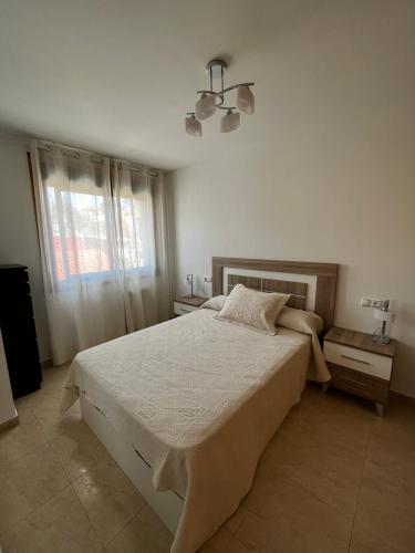 Un dormitorio con una cama grande y una ventana en Apartamento en Boiro en Escarabote