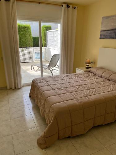 1 dormitorio con 1 cama grande y balcón en Amplio Apartamento con acceso directo a piscina en Platja  d'Aro