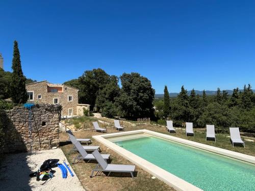 une piscine avec des chaises longues et une maison dans l'établissement Havre de paix à Chamaret - Gite de charme en Drôme Provençale, à Chamaret
