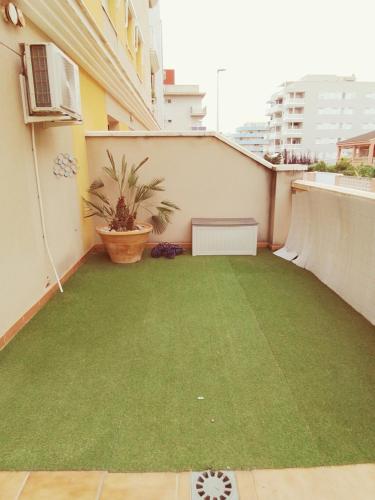 a small balcony with a green lawn on a building at Apartamento Analema con piscina wifi y aire acondicionado in Moncófar