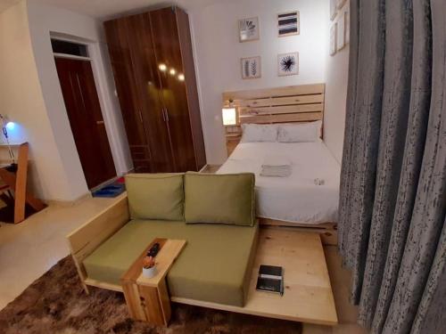ein kleines Schlafzimmer mit einem Bett und einem Sofa in der Unterkunft EnN 2 Lovely Premium Apartment in Bungoma
