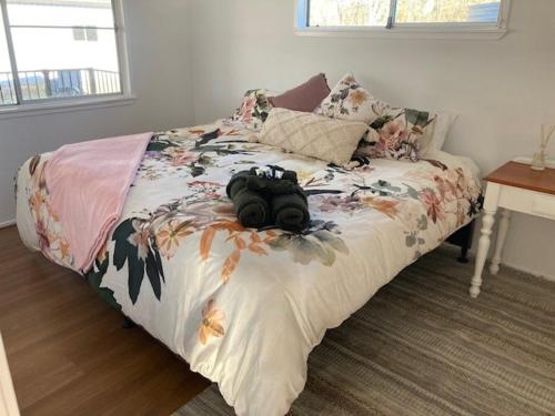 a camera laying on a bed in a bedroom at Clarendon Cottage , near lowood in Clarendon