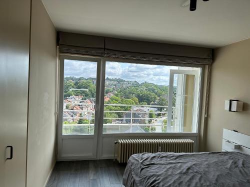 - une chambre avec une grande fenêtre offrant une vue dans l'établissement Clam，grand apartment in Uccle, à Bruxelles