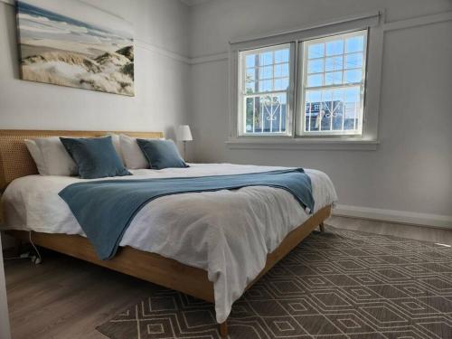 a bedroom with a large bed and two windows at WOW - King Beds, Huge Yard, New Reno, close to Beach, Private, Level no stairs in Sydney