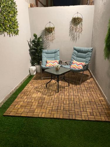 un patio con 2 sillas y una mesa sobre hierba en Riyadh, en Riad