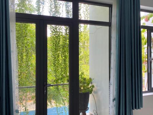 a window with a view of a tree at LA GAI HOMESTAY HOI AN in Hoi An