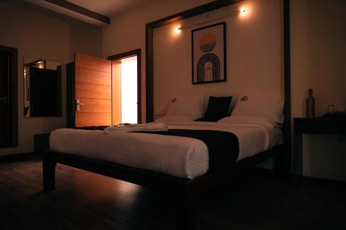 ein großes Bett in einem Zimmer mit Fenster in der Unterkunft Mellow Mount Private Homestay in Udagamandalam