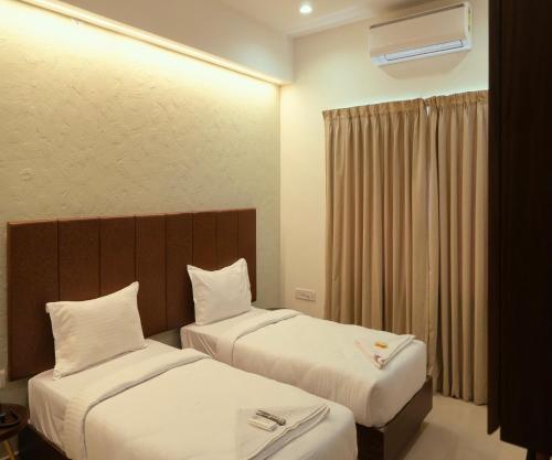 een hotelkamer met 2 bedden en een raam bij FLORA PAVILLION in Chennai