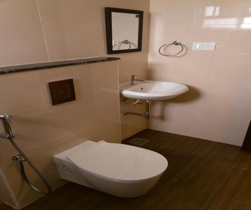 een badkamer met een toilet en een wastafel bij FLORA PAVILLION in Chennai