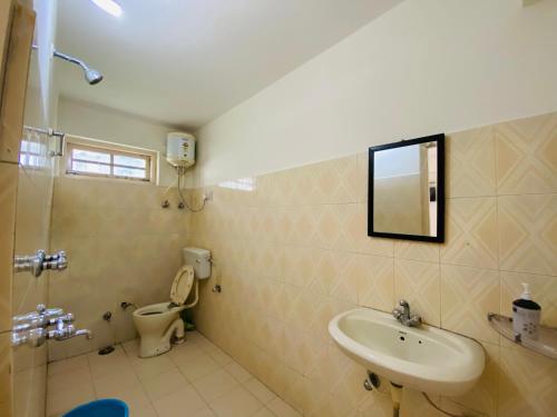 a bathroom with a sink and a toilet at Rahgir Mcleodganj in McLeod Ganj