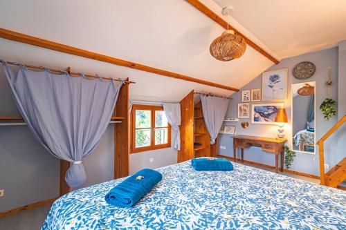 ein Schlafzimmer mit einem großen Bett mit blauer Bettwäsche in der Unterkunft GîTE DES CROIX 