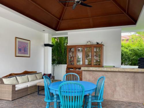 a patio with a blue table and chairs and a couch at Siam Jewel - Private pool villa in Bang Tao in Bang Tao Beach