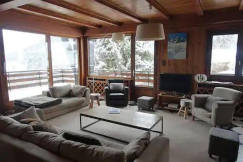een woonkamer met een bank en een tafel bij La villa des Tacounets 20 pers in Saint-Gervais-les-Bains