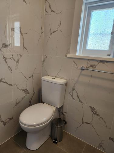 a bathroom with a white toilet and a window at WOW - King Beds, Huge Yard, New Reno, close to Beach, Private, Level no stairs in Sydney