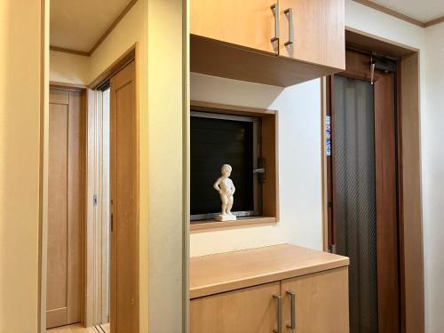 une cuisine avec une armoire et une statue. dans l'établissement 新規OPEN8割！1棟貸切・10名可能！秋葉原まで13分、新宿まで32分／スカイツリー近く, à Tokyo