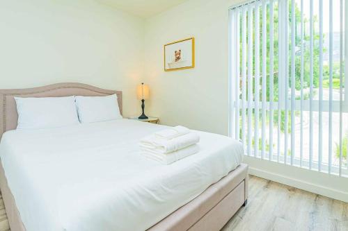 Dormitorio blanco con cama con sábanas blancas y ventana en 2B2B APT Newly Remodeled en Pasadena
