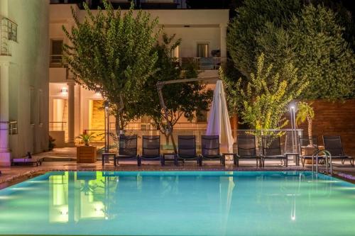 a swimming pool at night with chairs and a umbrella at Costa Maya Bodrum in Bodrum City