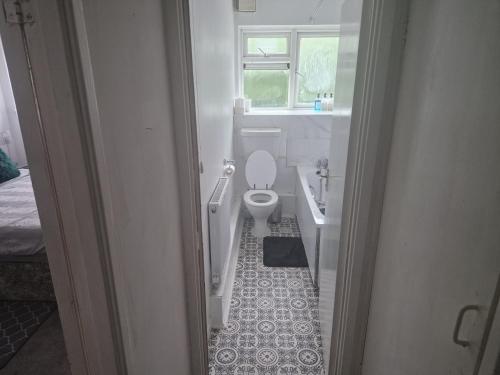 Immaculate 1-Bed Apartment in Woodford Green في وودفورد غرين: حمام مع مرحاض ومغسلة ونافذة