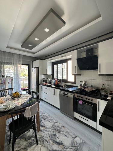 a large kitchen with a table and a dining room at Konforlu in Aydın