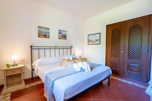 a bedroom with two beds and a wooden door at [PORTO CERVO] Accanto alla spiaggia & vista Mare in Porto Cervo