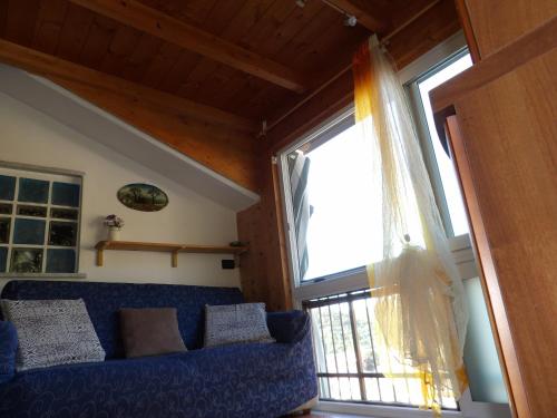 sala de estar con sofá azul y ventana en Gala, en Casarza Ligure