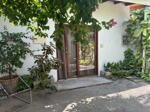 a front door of a white house with plants at Aqua oasis in Thoddoo