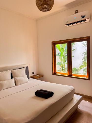 a bedroom with a large white bed with a window at Casa Flores in Kuta Lombok