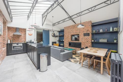 Les appartements de l'atelier paris 15 في باريس: مطبخ وغرفة معيشة مع طاولة وأريكة