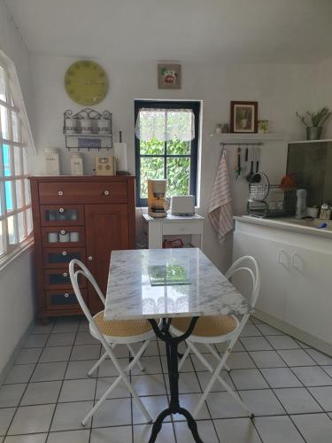 une cuisine avec une table et des chaises dans l'établissement La Maison de Jeanne, à Lesparre-Médoc