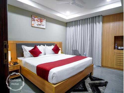 a hotel room with a large bed with red pillows at Saltstayz Select - Golf Course Road & Sector 57 in Gurgaon