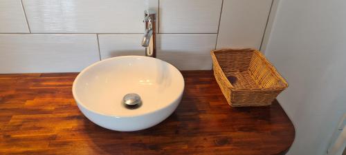 a bathroom with a white sink and a basket at Paradies Caraïbes III in Les Abymes