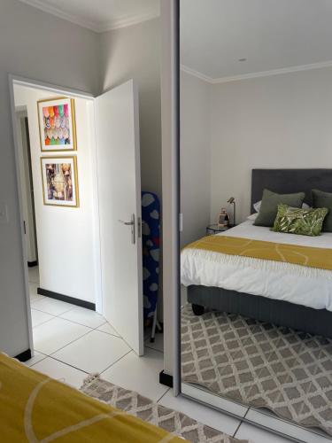 a bedroom with a bed and a mirror at Fourways Luxe Suite in Sandton
