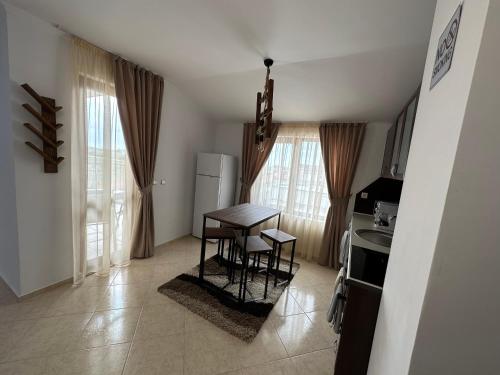 a kitchen with a table and chairs in a room at PANTELI APART HOUSE in Aheloy