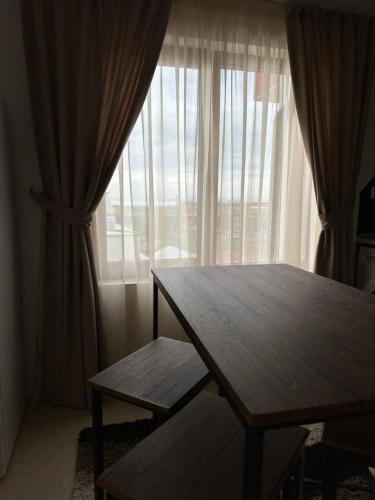 a table and bench in front of a large window at PANTELI APART HOUSE in Aheloy
