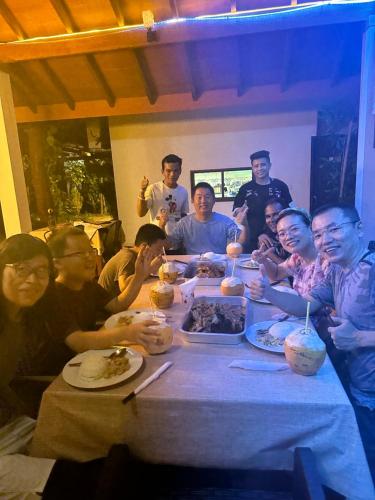 a group of people sitting around a table eating food at Aqua oasis in Thoddoo