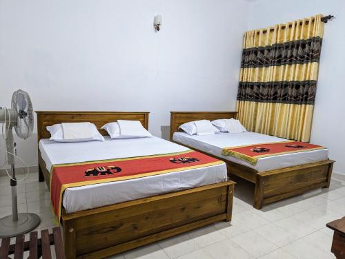 dos camas sentadas una al lado de la otra en una habitación en Moon Water's Edge, en Kandy