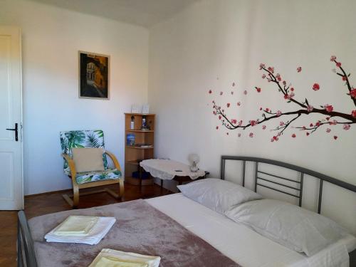 1 dormitorio con 1 cama, 1 silla y 1 árbol en Apartment Gulin, en Šibenik