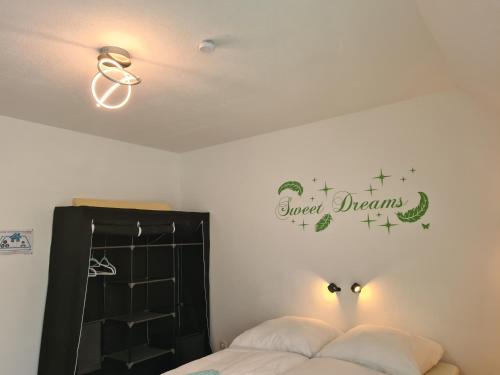 sypialnia z łóżkiem i znakiem na ścianie w obiekcie Lichtdurchflutetes Zimmer - Käppele w mieście Waldbüttelbrunn