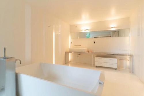 eine weiße Küche mit einer großen weißen Badewanne in einem Zimmer in der Unterkunft L'Atelier du Château in Nazelles