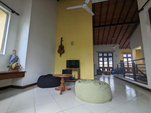 a living room with a table and a guitar on the wall at Culture Hub Backpack Hostel in Sri Jayewardenepura Kotte