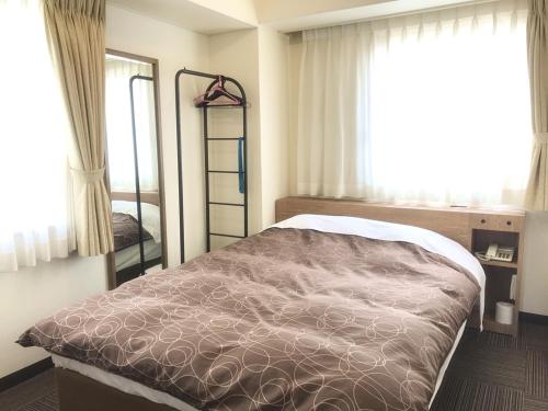 sypialnia z łóżkiem i oknem w obiekcie Ichinomiya Green Hotel w mieście Ichinomiya