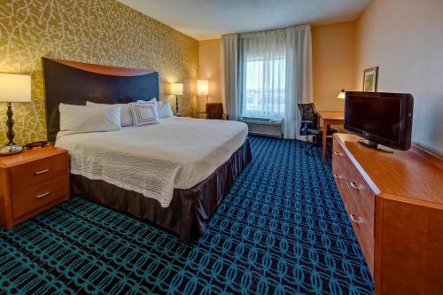 a hotel room with a bed and a flat screen tv at Fairfield Inn & Suites by Marriott Oklahoma City NW Expressway/Warr Acres in Oklahoma City