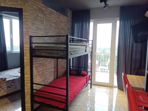 een slaapkamer met 2 stapelbedden en een bakstenen muur bij Crimson Serenity Appartment in Ureki