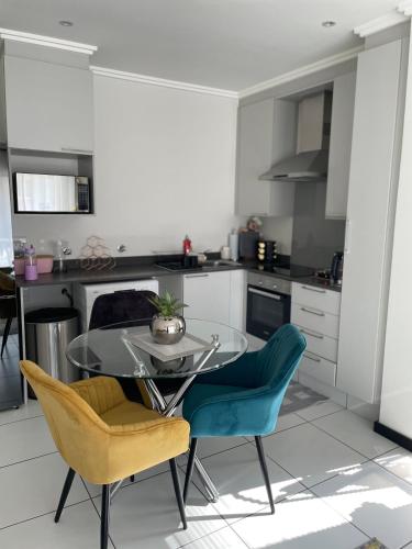 a kitchen with a glass table and two chairs at Fourways Luxe Suite in Sandton