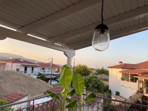 a porch with awning and a pendant light at Kikkos Village House in Néa Koróni