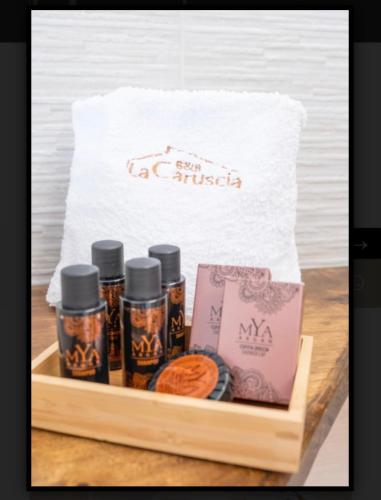 a wooden tray with four bottles of sauce and a bag of cookies at B&B La Caruscia in Trivento