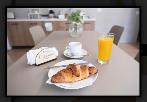 a table with a plate of food and a glass of orange juice at B&B La Caruscia in Trivento