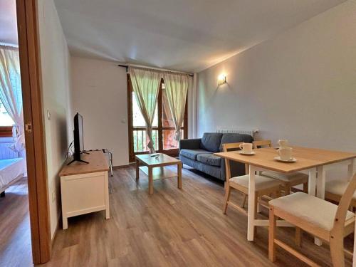 ein Wohnzimmer mit einem Sofa und einem Esstisch in der Unterkunft Pleta de Soldeu 345 hasta 4 personas. in Canillo